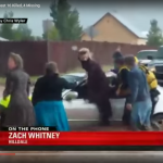 A screen capture of a video showing people being pulled from a trapped car in a flooded roadway in Hildale, Utah.
